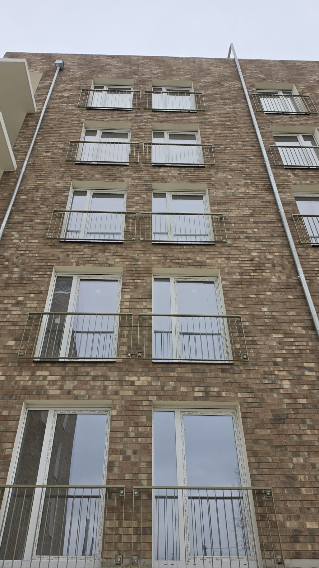 Detailaufnahme einer Klinkerfassade mit französischen Balkonen